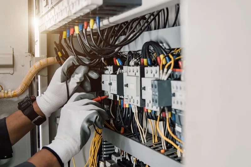 Electrician testing a commercial switchboard